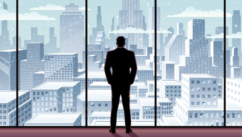 Businessman watching over the city from the window of his office. Assessing winter conditions.